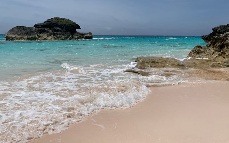 Pink sand beach with turquoise water and rock formations in Bermuda